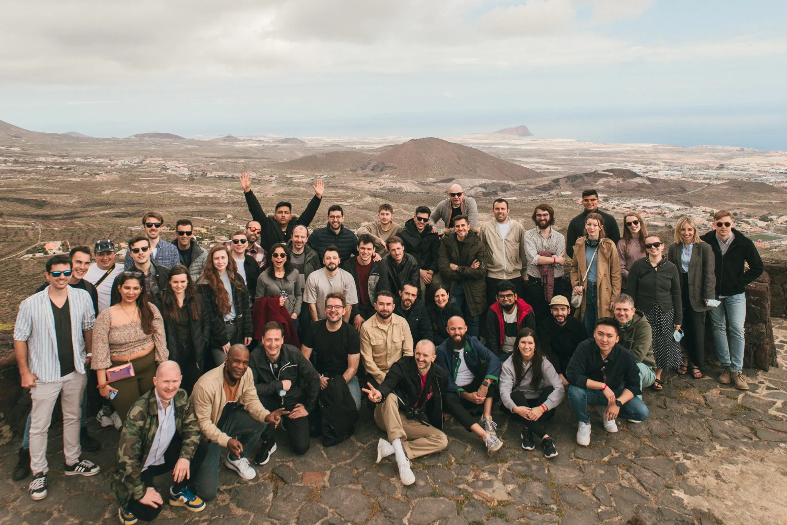 The Certainly team on a company retreat, gathered on a hilltop overlooking a volcanic landscape